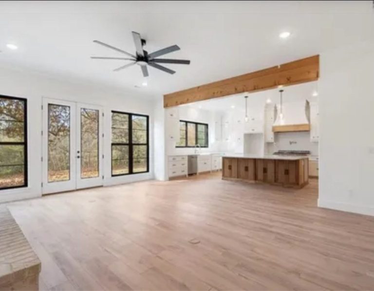 Rogers Arkansas Spacious modern living area with large windows and wood accents.